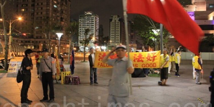圖爲日前法輪功學員舉辦活動時,愛國同心會成員揮舞紅旗騷擾。 (圖/大紀元)