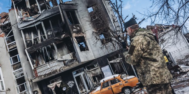 圖為2022 年 3 月 13 日一名士兵在烏克蘭哈爾科夫的一座被毀建築前，俄羅斯的襲擊仍在繼續。（圖片來源：Getty Images）