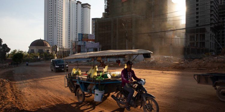 SIHANOUKVILLE - FEBRUARY 16 : A Cambodian motorcycle cart drives down a dirt road in Sihanoukville, Cambodia on February 16, 2020. Chinese are permanently changing the quiet oceanside resort. Cambodia's tourism and real estate sectors will experience slowdowns in the first half of 2020 as a result of the coronavirus: COVID-19. Money from China has created of new roads, airports, skyscrapers, dams, hotels, casinos, restaurants and apartments. Cambodia has been heavily criticized from Western nations over its shrinking political freedoms, has grown increasingly closer to China in recent years and stands as the largest benefactor from Chinas influence in Southeast Asia.
(Photo by Paula Bronstein/Getty Images )