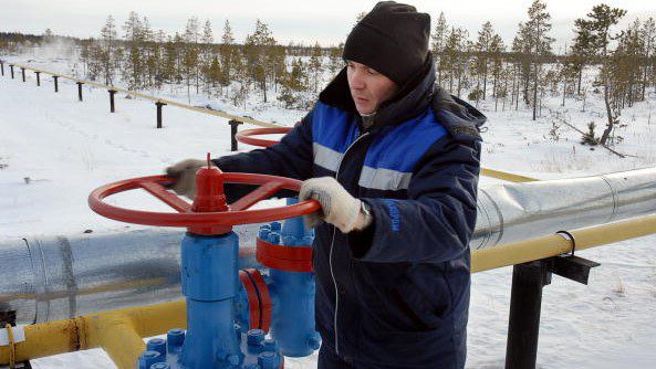 圖為一名工人在西伯利亞諾亞布斯克鎮外打開俄羅斯 Gazprom 企業的天然氣管道閥門。