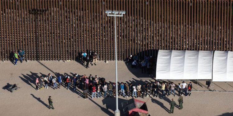 YUMA, ARIZONA - SEPTEMBER 28: Immigrants await processing by U.S. Border Patrol agents while seeking asylum in the United States on September 28, 2022 near Yuma, Arizona. U.S. immigration authorities made more than 2 million arrests along the U.S. southern border during the 2022 fiscal year, which ends September 30, the first time to reach that historic threshold. (Photo by John Moore/Getty Images)