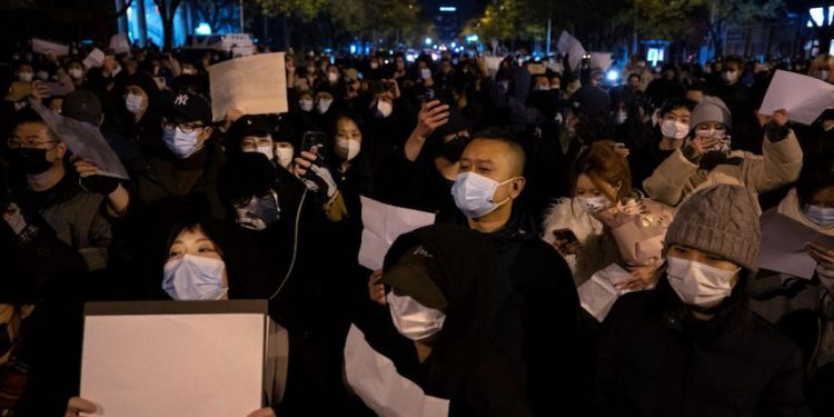 2022年11月27日,在中國北京,抗議者舉着一張反對審查制度的白紙,在抗議中共苛刻的清零政策。(圖片: Kevin Frayer/Getty Images)