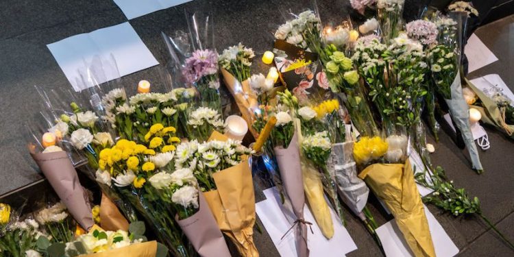 2022年11月28日,數十名香港抗議者用鮮花和白紙來悼念在烏魯木齊火災中逝者、以及聲援那些在中國集會反對中共清零政策的抗議者。(圖片: Ben Marans/SOPA Images/LightRocket via Getty Images)