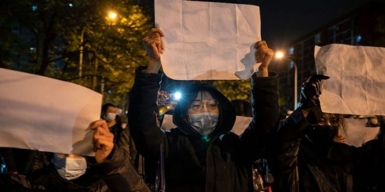 2022年11月27日,在中國北京,抗議者舉着一張反對審查制度的白紙,抗議中共嚴格的「清零」措施。(圖片:Kevin Frayer/Getty Images)