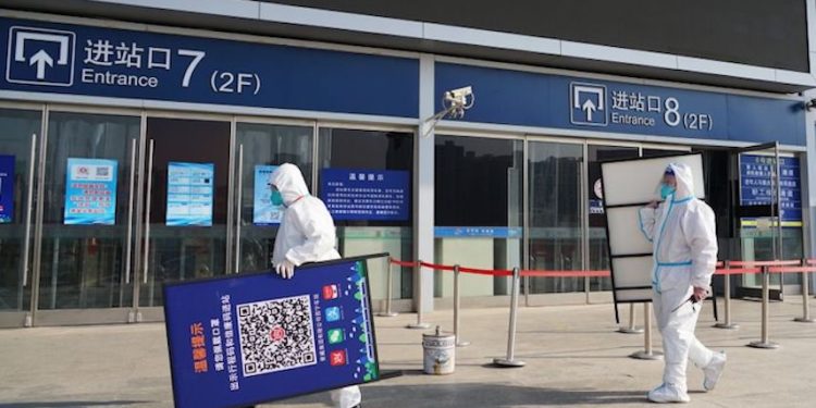 Editorial # 1447686977: 2022年12月8日,在中國青海省西寧市,「大白」工人在西寧火車站拆除出示核酸檢測陰性結果和健康碼二維碼標誌。(Photo by Ma Mingyan/China News Service/VCG via Getty Images)