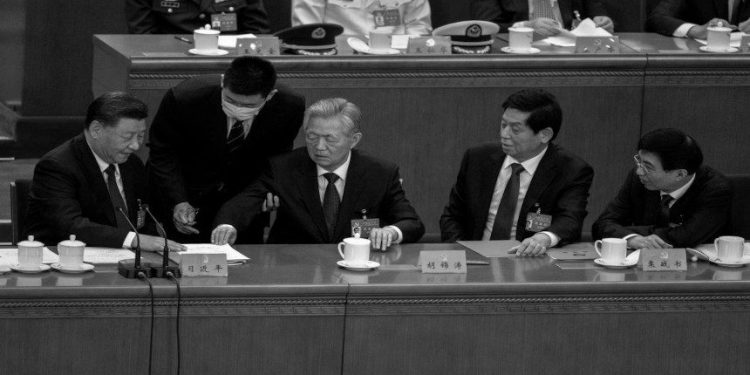 BEIJING, CHINA - OCTOBER 22: Chinese President Xi Jinping, (L) Li Zhanshu, (2nd R), and Wang Huning, (R) look on as former President Hu Jintao, (C) touches documents in from of Xi before he is helped to leave early from the closing session of the 20th National Congress of the Communist Party of China, at The Great Hall of People on October 22, 2022 in Beijing, China. (Photo by Kevin Frayer/Getty Images)