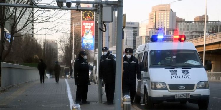 2022年11月29日，中共警察在北京亮馬河邊的一條路上監視。(圖片：NOEL CELIS/AFP via Getty Images)