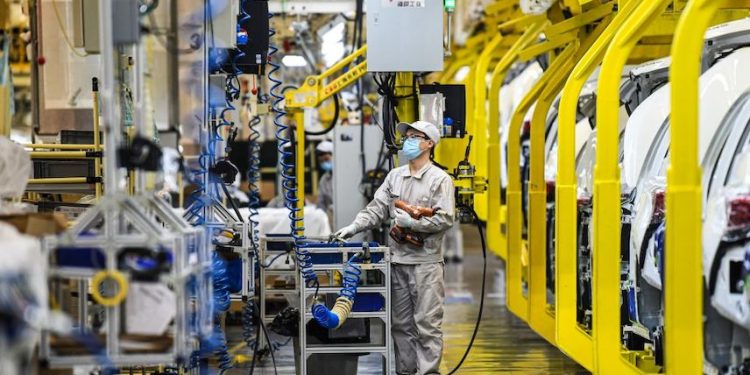 外媒：北京防疫政策導致國際汽車供應鏈與中脫鉤。圖為2020年9月24日，在中國新疆烏魯木齊市廣汽集團新疆汽車廠的工人。(圖片：Wang Fei/Xinhua via Getty)