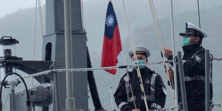 應對中共 台灣宣佈延長義務兵役。圖為2020年 12 月 15 日兩名台灣海軍士兵在一艘快艇上進行升旗儀式。（圖片來源: SAM YEH/AFP via Getty Images）