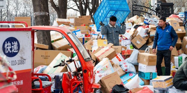 2022年12月20日,在中國北京,快遞員在一個京東快遞站分揀包裹。(圖片: Hou Yu/China News Service/VCG via Getty Images)
