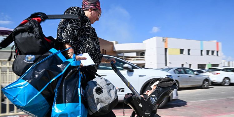 SDEROT, ISRAEL - OCTOBER 15: Families arrive with suitcases to busses after evacuation orders are issued on October 15, 2023 in Sderot, Israel. Israel has sealed off Gaza and launched sustained retaliatory air strikes, which have killed at least 1,400 people with more than 400,000 displaced, after a large-scale attack by Hamas. On October 7, the Palestinian militant group Hamas launched a surprise attack on Israel from Gaza by land, sea, and air, killing over 1,300 people and wounding around 2,800. Israeli soldiers and civilians have also been taken hostage by Hamas and moved into Gaza. The attack prompted a declaration of war by Israeli Prime Minister Benjamin Netanyahu and the announcement of an emergency wartime government. (Photo by Alexi J. Rosenfeld/Getty Images)