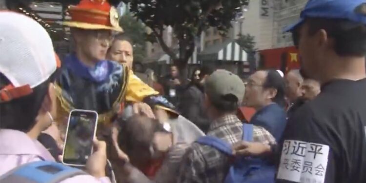 因為自己的哥哥被粉紅圍毆，身穿清朝皇帝龍袍的抗議者暴打「歡迎」習近平的粉紅（網絡視頻截圖）