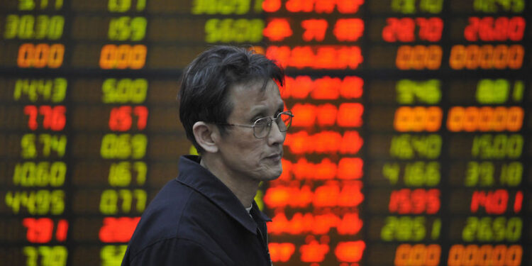 An invester passes an electronic board showing stock prices at a securities brokerage in Beijing as Chinese shares opened 6.12 percent lower on March 20, 2008 as investors reacted to a sharp retreat on Wall Street overnight. Already weak investor confidence took another beating after the decline on Wall Street with the Dow Jones Industrial Average down 2.36 percent, shrugging off the Federal Reserve's recent interest rate cut. AFP PHOTO/Peter PARKS (Photo credit should read PETER PARKS/AFP via Getty Images)