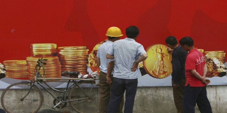 NANCHANG, CHINA - MAY 6: (CHINA OUT) Migrant workers view gold coins painted on a real estate billboard on May 6, 2006 in Nanchang of Jiangxi Province, China. Seventy-six percent of Chinese migrant workers get no bonuses for working overtime in holidays, said a report by the research center of the State Council. According to the report, migrant workers generally work for extra hours and under stress without extra pay. Some employers even hold out their pay to force them work overtime, according to state media. (Photo by China Photos/Getty Images)