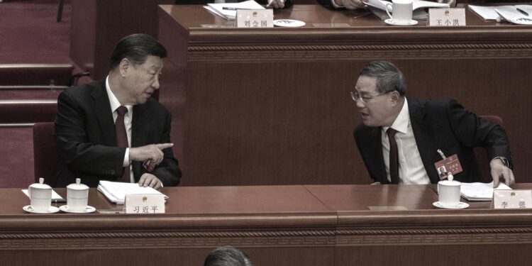 圖為2024年3月5日,中共黨魁習近平在北京人民大會堂開幕式上發表講話後與總理李強交談 (Photo by Kevin Frayer/Getty Images)