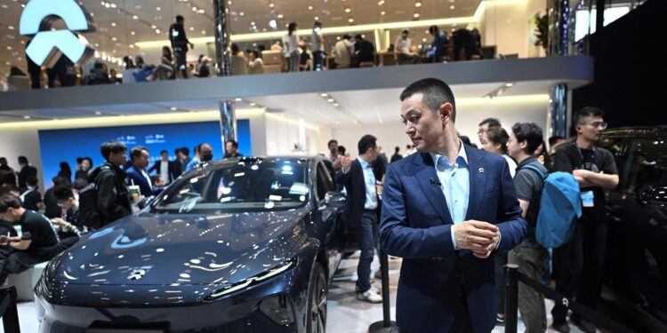 William Li, CEO of Nio Chinese multinational automobile manufacturer, stands next to Nio ET7 model electric car during an AFP interview at the Beijing Auto Show in Beijing on April 25, 2024. (Photo by Pedro PARDO / AFP) (Photo by PEDRO PARDO/AFP via Getty Images)