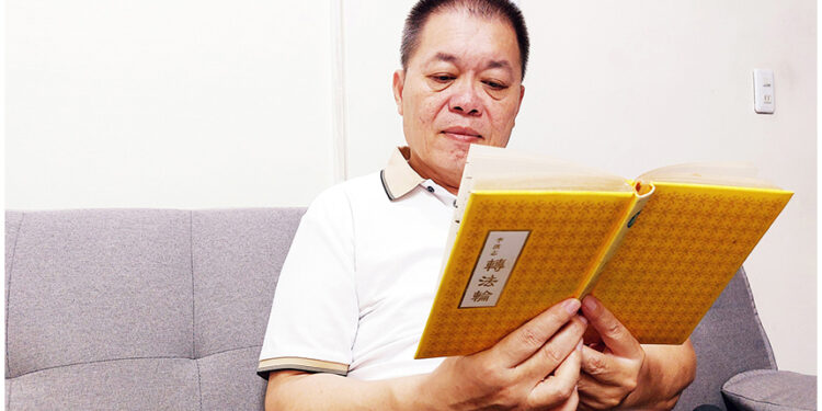 負債幾千萬，天無絕人之路，黑暗絕望中寶書把楊忠勛引向光明。圖為楊忠勛正在讀《轉法輪》。（圖片來源：明慧網）