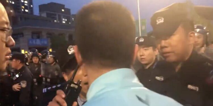 中國足球又爆大規模衝突!廣州大連球員混戰 球迷與警察爆發衝突並逼警察道歉。圖為球迷在和警察理論(網絡視頻截圖)