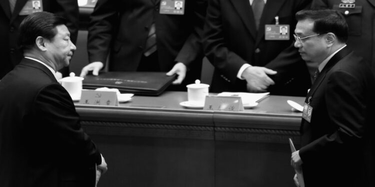 BEIJING, CHINA - NOVEMBER 14: China's Vice President Xi Jinping (L) and China's Vice-Premier Li Keqiang (R) leave their seats after the closing session of the 18th National Congress of the Communist Party of China (CPC) at the Great Hall of the People on November 14, 2012 in Beijing, China. Members of the Standing Committee of the Political Bureau of the new CPC Central Committee will meet with journalists on November 15, 2012. (Photo by Feng Li/Getty Images)