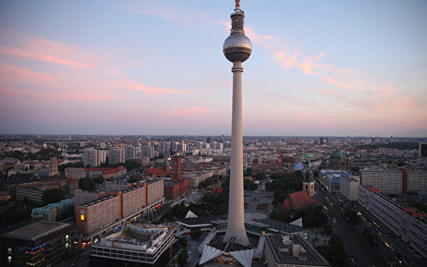 BERLIN, GERMANY - JUNE 18: The broadcast tower at Alexanderplatz looms over the city center at sunset on June 18, 2014 in Berlin, Germany. Alexanderplatz, a crossing point of tourists, commuters, shoppers, lovers, artists, bums and petty criminals, was built from the rubble of World War II by the communist authorities of former East Germany and today is the nexus of the reunified city. (Photo by Sean Gallup/Getty Images)
