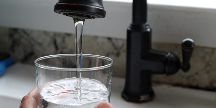 SAN ANSELMO, CALIFORNIA - JULY 06: In this photo illustration, water from a tap fills a glass on July 06, 2023 in San Anselmo, California. According to a study by the US Geological Survey, nearly half of the tap water in the United States is contaminated with "forever chemicals" that are considered dangerous to human health. Per and polyfluorinated alkyl substances, or PFAS, are chemicals that linger in the body and are linked to health issues like cancer, obesity, liver damage, decreased fertility, thyroid disease, high cholesterol and hormone suppression. (Photo Illustration by Justin Sullivan/Getty Images)