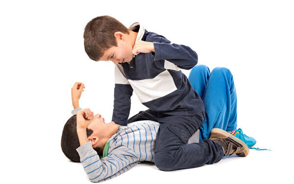 Young boys fighting isolated in white