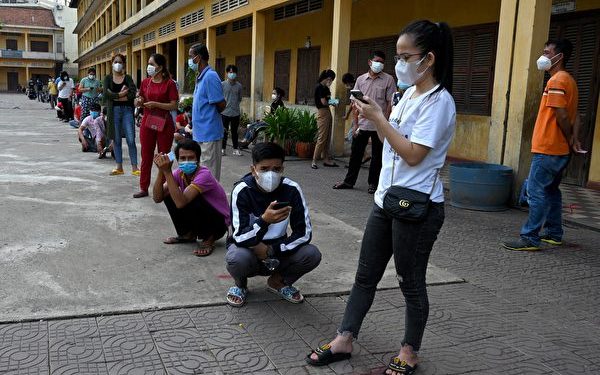 People wait in line to receive the Sinopharm vaccine from China at a school in Phnom Penh on April 30, 2021 as part of government campaign to halt the spiraling Covid-19 coronavirus cases. (Photo by TANG CHHIN Sothy / AFP)